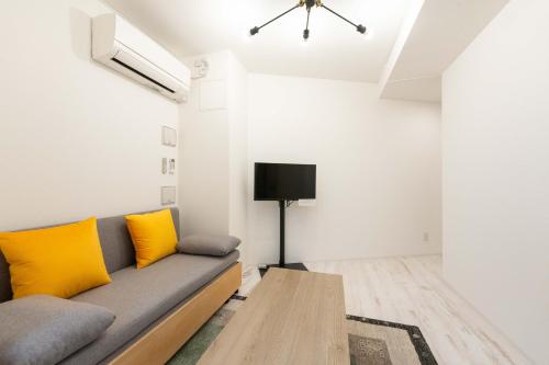 a living room with a couch and a table at TASUKI smart Higashishinjuku in Tokyo