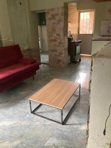 un soggiorno con divano rosso e tavolino da caffè di N4 1 Casa Céntrica Próxima al Puente Internacional de la Concordia a Artigas