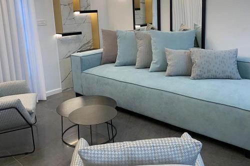 uma sala de estar com um sofá azul e uma mesa em סוויטות שלווה עילאית em Sifsufa