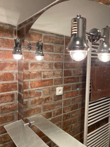 a bathroom with a mirror and a sink and lights at Chalupa u Brčáků in Ktiš