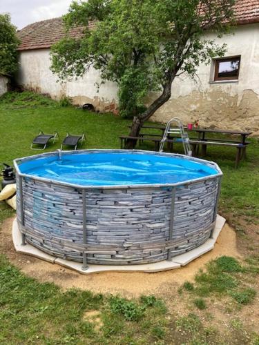 a hot tub in a yard with a tree at Chalupa u Brčáků in Ktiš
