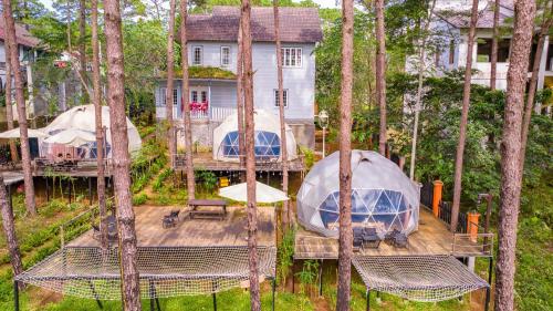 an aerial view of a house with tents in the trees at De Vivre Homestay Măng Đen in Kon Von Kla