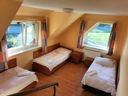 um quarto com duas camas e duas janelas em Gościniec u Zawierki em Lódź