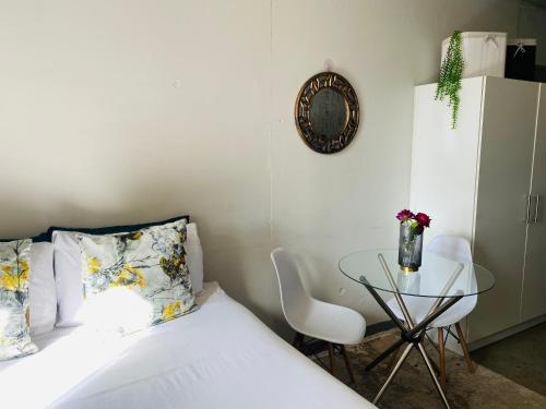 een slaapkamer met een bed en een glazen tafel bij Views from The 509 in Johannesburg