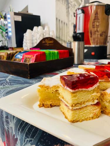 a plate with three pieces of cake on a table at Old Tree Home & Restaurant in Oświęcim