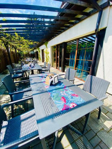 a row of tables and chairs on a patio at Old Tree Home & Restaurant in Oświęcim