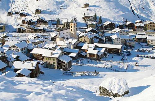 a small town covered in snow with buildings at Grosshus Vals in Vals