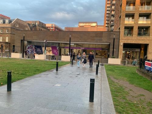 un grupo de personas caminando delante de un edificio en Luxury Riverside Apt with easy access to Central London, O2, Excel centre and Parking en Woolwich