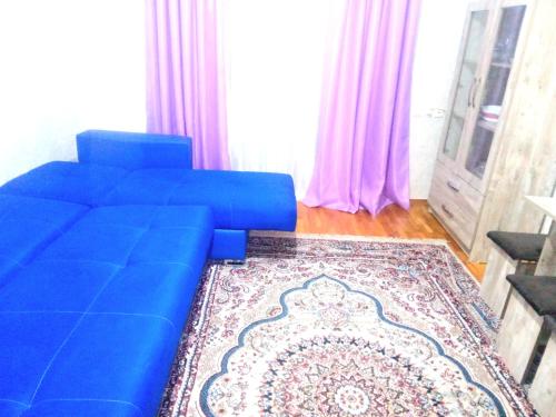 a blue couch in a living room with a rug at NIZAMI Street flat in Baku