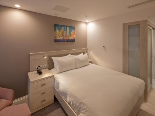 a bedroom with a white bed and a chair at Hampton By Hilton Leeds City Centre in Leeds