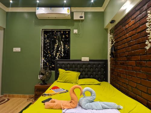 due cigni seduti su un letto in una stanza di Budget-Friendly Luxury Air-Conditioned Deluxe Suite at Pravuprasad Homestay a Bhubaneshwar