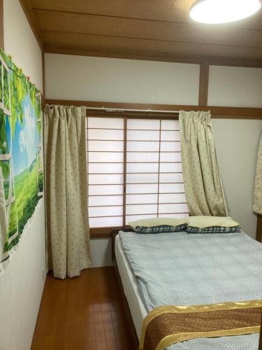 a bedroom with a bed and a window with curtains at 3-min to Station,5BR, 1LR villa near Asakusa, 95平米5间卧室休息好 Stay Dream Hotel in Tokyo