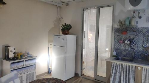 a kitchen with a white refrigerator and a window at Brezza Marina in Isola delle Femmine