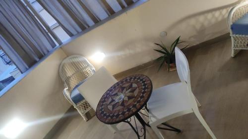 un balcon avec des chaises, une table et une plante dans l'établissement Brezza Marina, à Isola delle Femmine