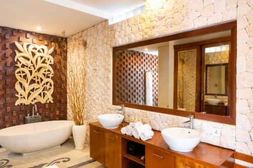 y baño con 2 lavabos, bañera y espejo. en Affordable villa @Nyanyi, near Tanah Lot Temple, en Munggu