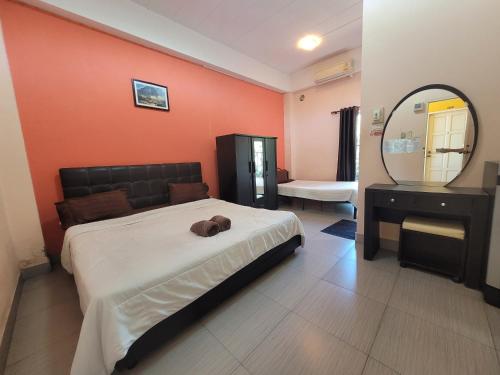 1 dormitorio con 1 cama grande y espejo en โรงแรมบ้านเปรมศิริ, en Amnat Charoen