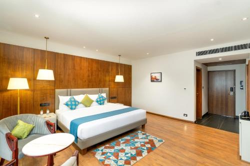 a hotel room with a bed and a table and chairs at Cygnett Inn Imperial Tezpur in Tezpur