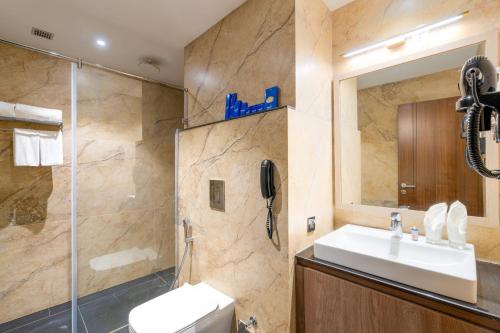 a bathroom with a sink and a shower at Cygnett Inn Imperial Tezpur in Tezpur