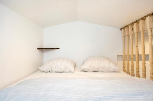 een slaapkamer met een bed met 2 kussens erop bij Villa des palmiers, Studio cosy in Villeneuve-sur-Lot