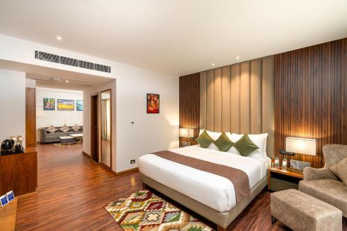 a bedroom with a bed and a living room at Cygnett Inn Imperial Tezpur in Tezpur