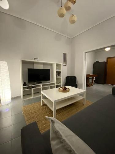 a living room with a white table and a tv at Elia's boutique apartment in Sparti