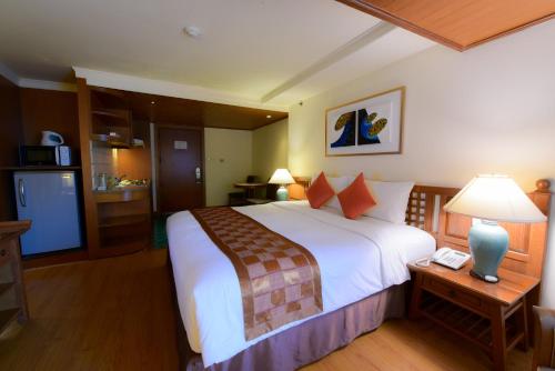 a hotel room with a large bed and a telephone at Silom Serene A Boutique Hotel in Bangkok