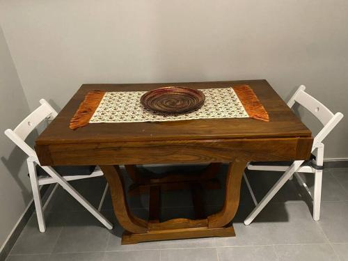 a wooden table with two white chairs and a table with a coil at Elia's boutique apartment in Sparti