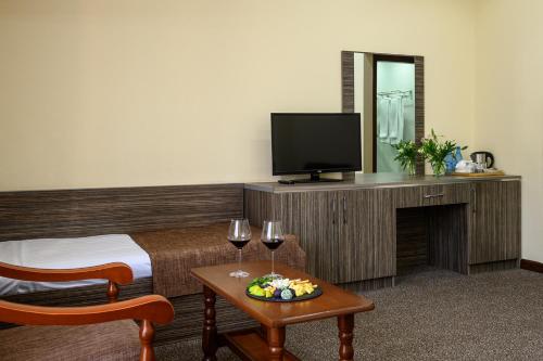 a hotel room with a bed and a table with wine glasses at Alpina Resort by Stellar Hotels, Tsaghkadzor in Tsaghkadzor