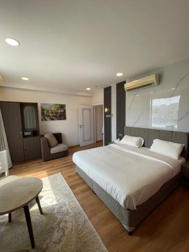 ein Schlafzimmer mit einem großen weißen Bett und einem Sofa in der Unterkunft Nizwa Park House Apartment in Nizwa