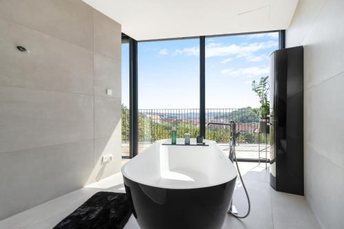 a bathroom with a bath tub and a large window at Luxury Penthouse Prague in Prague