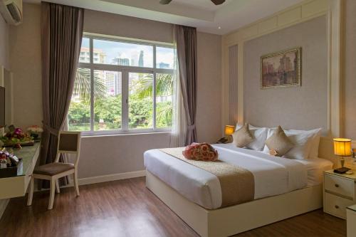 ein Hotelzimmer mit einem Bett und einem Fenster in der Unterkunft Anik Boutique Hotel in Phnom Penh