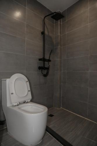 a bathroom with a white toilet and a shower at Bassa nova villa in Panglao