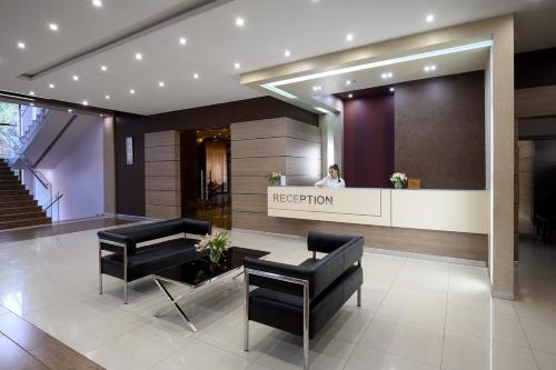 a reception area of a hotel with black chairs and a person at Alpina Resort by Stellar Hotels, Tsaghkadzor in Tsaghkadzor