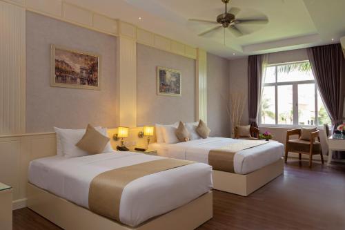 a hotel room with two beds and a window at Anik Boutique Hotel in Phnom Penh