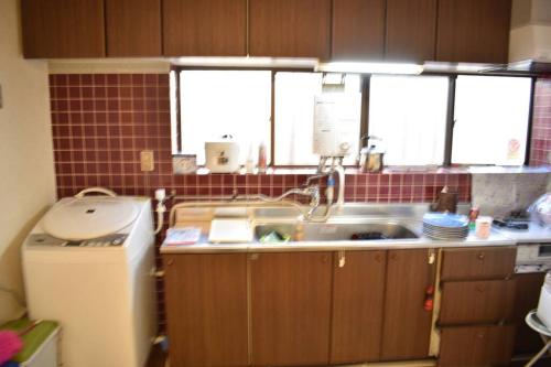a kitchen with a sink and a refrigerator at cheaper for 6th & 7th guest 市街地中心部 一棟貸しの宿 GUEST HOUSE DON'S HOME in Takayama
