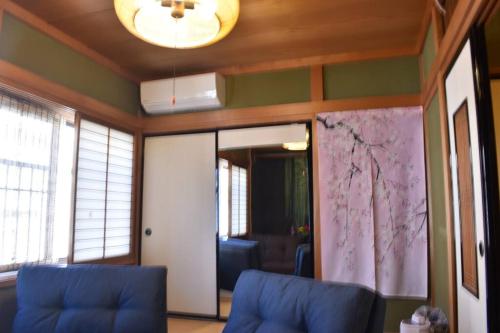 a living room with two blue chairs and a ceiling at cheaper for 6th & 7th guest 市街地中心部 一棟貸しの宿 GUEST HOUSE DON'S HOME in Takayama