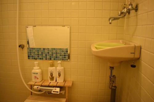 a bathroom with a sink and a toilet and a mirror at Only for one group Cheaper for 6th & 7th guest 市街地中心部 一棟貸しの宿 in Takayama