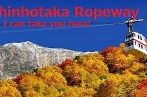 a lighthouse on a hill with a mountain in the background at Only for one group Cheaper for 6th & 7th guest 市街地中心部 一棟貸しの宿 in Takayama
