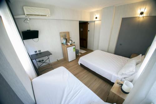 a hotel room with two beds and a television at Mekan Villa Otel in Selçuk
