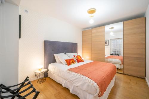 - une chambre dotée d'un lit avec deux oreillers orange dans l'établissement Loft familial au cœur de Paris avec Clim, Arcade et Baby-foot Proche République et Canal St Martin, à Paris