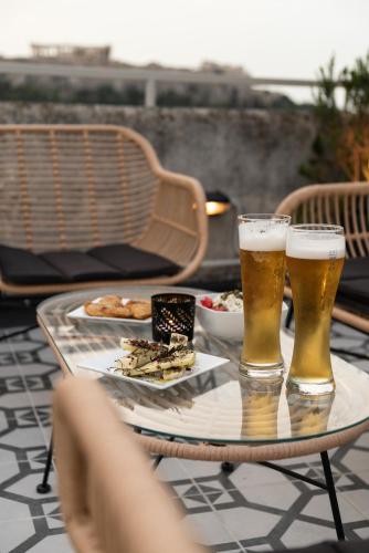 two glasses of beer and a plate of food on a table at ATHENS STORIES in Athens