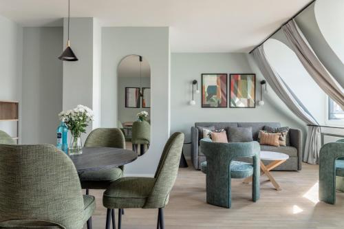 numa I Blend Apartments في ميونخ: غرفة معيشة مع طاولة وكراسي وأريكة