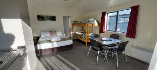 Habitación pequeña con cama y mesa en Omarama TOP10 Holiday Park en Omarama
