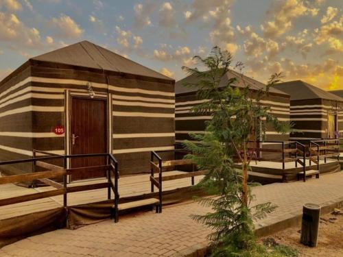 - un petit bâtiment avec une terrasse couverte et une porte en bois dans l'établissement Desert stars, à Wadi Rum