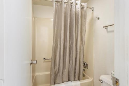 La salle de bains est pourvue d'une douche avec rideau de douche. dans l'établissement Econo Lodge University, à Lawrence