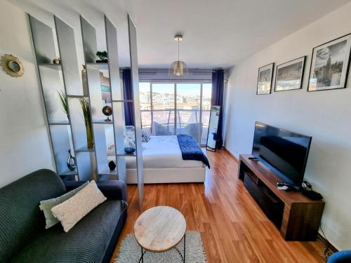 a living room with a bed and a couch at Appartement T1 Marseille Prado Chanot Plage in Marseille