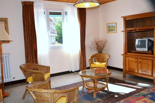 - un salon avec une table, des chaises et une télévision dans l'établissement Résidence Torremagne 1, à Font-Romeu-Odeillo-Via