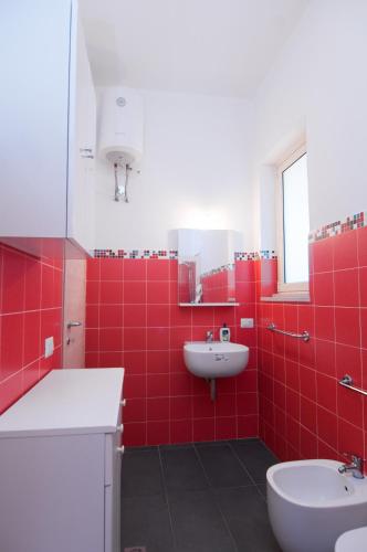 a red bathroom with a sink and a toilet at Villa Bruffalori in Sampieri