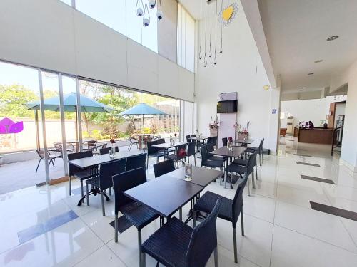 HOTEL TILAMAS في Dares: غرفة طعام مع طاولات وكراسي ونوافذ