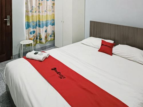 łóżko z czerwonym kocem na górze w obiekcie RedDoorz Syariah At Jalan Doktor Warsito Lampung w mieście Bandar Lampung